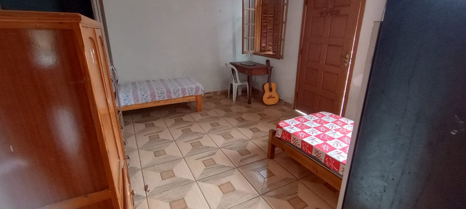 Quarto duplo com mesa de estudo e armários.