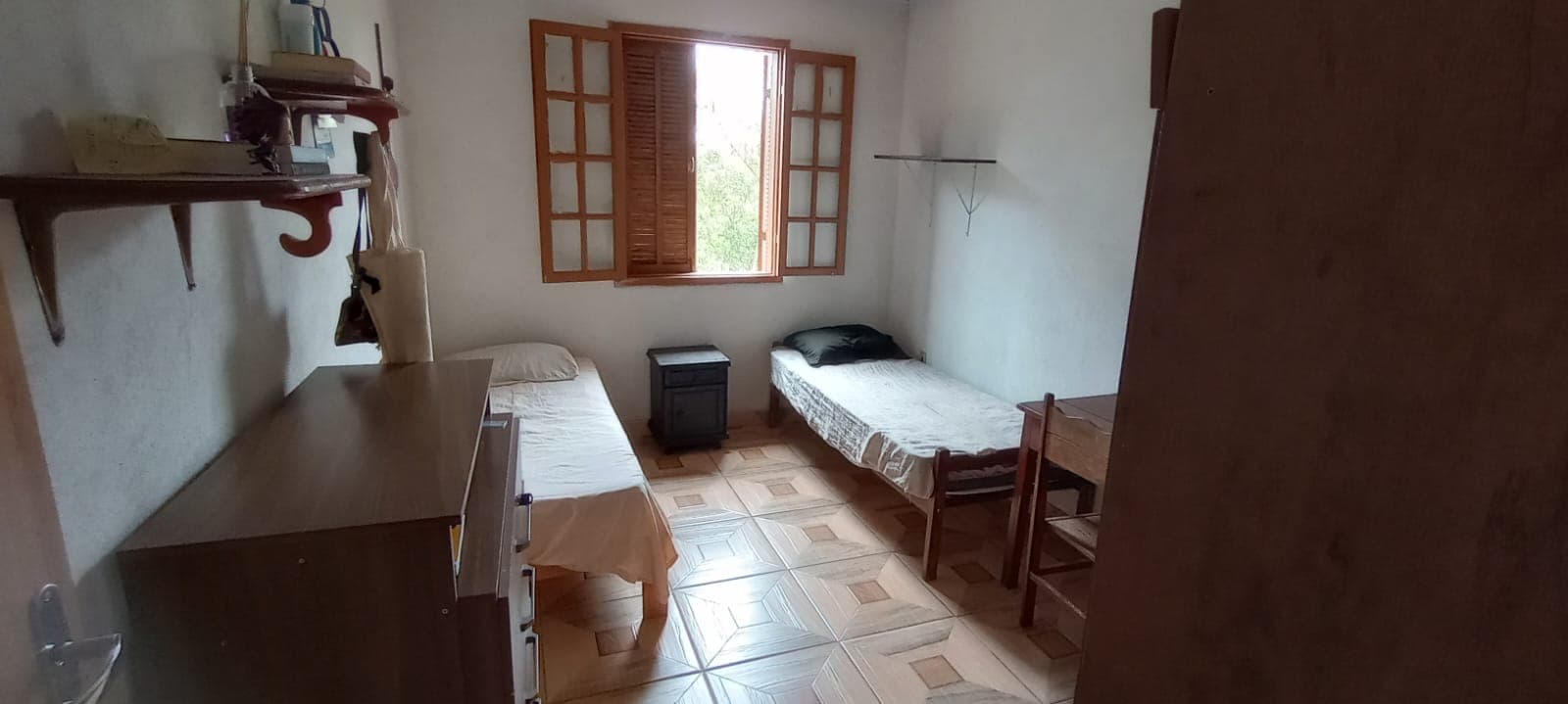 Quarto duplo com mesas de estudo e armários.